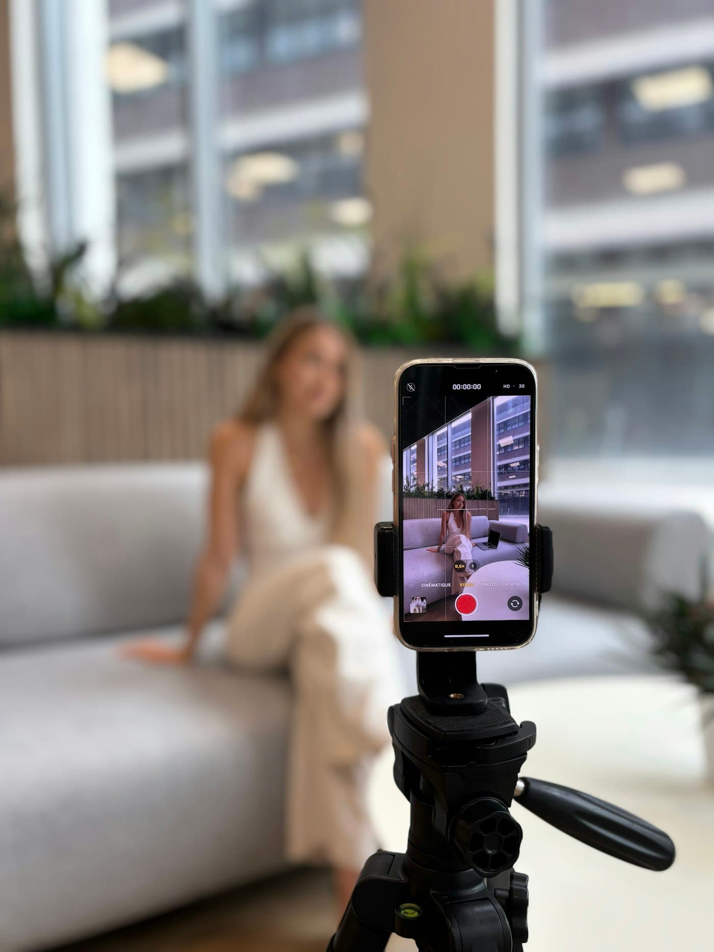 A creator recording herself on a phone mounted on a tripod